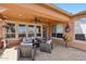 Inviting covered patio with cozy seating and travertine flooring provides a great outdoor living space at 28351 N 130Th Dr, Peoria, AZ 85383