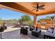 Covered patio with a built-in grill, dining area, outdoor seating, and desert landscaping at 28351 N 130Th Dr, Peoria, AZ 85383