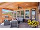 Inviting covered patio featuring a built-in grill, comfortable seating, and travertine flooring at 28351 N 130Th Dr, Peoria, AZ 85383