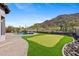 Lush backyard featuring a pool, putting green, and scenic mountain views at 3529 N Boulder Canyon St, Mesa, AZ 85207
