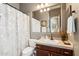Well-lit bathroom with a large mirror, vanity with dark wood cabinets, and shower with decorative curtain at 3529 N Boulder Canyon St, Mesa, AZ 85207