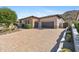 Paver driveway leads to a two-car garage, with desert landscaping and stone accents on the home's facade at 3529 N Boulder Canyon St, Mesa, AZ 85207