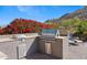 A well-equipped outdoor grill area with stainless steel appliances and a beautiful backdrop of vibrant red flowers at 3529 N Boulder Canyon St, Mesa, AZ 85207