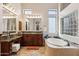 Main bathroom with soaking tub, dual vanity, and granite countertops, with natural light at 3529 N Boulder Canyon St, Mesa, AZ 85207