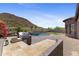 Outdoor kitchen featuring a built-in grill overlooks a sparkling pool and landscaped backyard with mountain views at 3529 N Boulder Canyon St, Mesa, AZ 85207