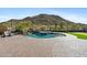 Backyard view of the sparkling pool, integrated hot tub, putting green, and beautiful desert mountain view at 3529 N Boulder Canyon St, Mesa, AZ 85207