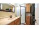 Bathroom includes a shower with glass door, wood cabinetry, and modern black stacked washer and dryer at 359 Felspar Dr, Apache Junction, AZ 85119
