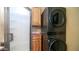 Bathroom features a glass enclosed shower, wood cabinetry, and black stacked washer and dryer at 359 Felspar Dr, Apache Junction, AZ 85119