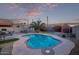 This backyard has a pool, putting green, desert landscaping, and outdoor dining area at 36469 W Alhambra St, Maricopa, AZ 85138