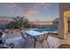 Outdoor dining area overlooking a sparkling pool and beautifully landscaped backyard at 36469 W Alhambra St, Maricopa, AZ 85138