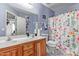 Bright bathroom with a double vanity, floral shower curtain, and ample storage space at 36469 W Alhambra St, Maricopa, AZ 85138