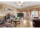 Spacious living room with a large TV, tile flooring, and neutral color scheme at 36469 W Alhambra St, Maricopa, AZ 85138