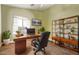Modern office with a sleek wooden desk, leather chair, and a bookshelf at 36469 W Alhambra St, Maricopa, AZ 85138