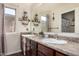 This bathroom features a double sink vanity with framed mirror, and decorative shelving at 38085 W San Capistrano Ave, Maricopa, AZ 85138