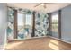 Bedroom features a modern accent wall, ceiling fan, and ample natural light from two windows at 38085 W San Capistrano Ave, Maricopa, AZ 85138
