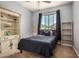 Cozy bedroom featuring natural light, a comfortable bed, and built-in shelving at 38085 W San Capistrano Ave, Maricopa, AZ 85138