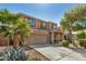 Two-story home features a large front yard, desert landscaping, attached two-car garage, and covered porch at 38085 W San Capistrano Ave, Maricopa, AZ 85138