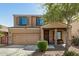 Two-story home features a large front yard, desert landscaping, attached two-car garage, and covered porch at 38085 W San Capistrano Ave, Maricopa, AZ 85138