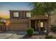 Two-story home features a large front yard, desert landscaping, attached two-car garage, and covered porch at 38085 W San Capistrano Ave, Maricopa, AZ 85138