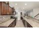 Spacious kitchen features stone countertops, tiled backsplash, stainless steel appliances, and lots of cabinet space at 38085 W San Capistrano Ave, Maricopa, AZ 85138