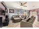 Spacious living room with a ceiling fan, tile flooring, and a comfortable sectional sofa and lounge chair at 38085 W San Capistrano Ave, Maricopa, AZ 85138