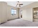 Spacious primary bedroom with neutral carpet, ceiling fan, and an entrance to the primary bathroom at 4216 N 27Th St # 108, Phoenix, AZ 85016