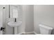 A modern half-bath with a pedestal sink, toilet, and neutral wall color at 4265 E John St, Gilbert, AZ 85295