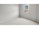 A minimalist bedroom with neutral carpet and a window overlooking a home exterior at 4265 E John St, Gilbert, AZ 85295