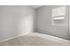 An empty bedroom with neutral carpet and a window, ready for customization at 4265 E John St, Gilbert, AZ 85295