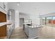 Bright kitchen showcasing granite counters, white cabinets, stainless vent hood, an island with sink and sliding glass doors at 4265 E John St, Gilbert, AZ 85295