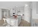 Open kitchen features granite countertops, white cabinets, subway tile backsplash, island seating and stainless steel appliances at 4265 E John St, Gilbert, AZ 85295