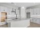 Bright, open kitchen featuring a large island with granite countertops, white cabinets, and stainless steel appliances at 4265 E John St, Gilbert, AZ 85295