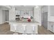 Bright kitchen showcasing granite counters, white cabinets, stainless vent hood, island seating and tiled floors at 4265 E John St, Gilbert, AZ 85295