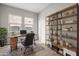Stylish home office featuring a wood desk, open shelving, and a comfortable leather chair at 4265 E John St, Gilbert, AZ 85295