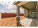 A covered patio, ready for furniture, with a view to a new backyard and block fence at 4265 E John St, Gilbert, AZ 85295