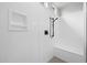 A sleek, modern shower with white walls, black fixtures, and a built-in bench at 4265 E John St, Gilbert, AZ 85295