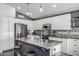 Stylish kitchen featuring white cabinetry, a mosaic backsplash, a gray island, and stainless steel appliances at 4665 E Goldfinch Gate Ln, Phoenix, AZ 85044
