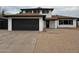 Charming two-story home featuring a dark garage door, manicured landscaping, and a cozy front porch at 5431 W Cholla St, Glendale, AZ 85304