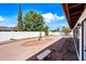 Beautiful backyard with mature trees, a charming water feature, gravel, and brick accents at 5434 E Acoma Dr, Scottsdale, AZ 85254
