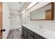Bathroom features vanity, a large mirror, shower over tub, and wood-style floors at 5434 E Acoma Dr, Scottsdale, AZ 85254