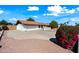 Lovely home with a circular driveway and well-maintained desert landscaping with shrubbery and a tile roof at 5434 E Acoma Dr, Scottsdale, AZ 85254