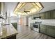 A spacious kitchen with an island, stainless appliances, and modern lighting is great for entertaining at 5434 E Acoma Dr, Scottsdale, AZ 85254