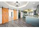 Open-concept kitchen features gray cabinets, granite counters, modern lighting, and barn doors to a sunroom at 5434 E Acoma Dr, Scottsdale, AZ 85254