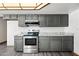 Kitchen features grey cabinetry, stainless appliances, stone countertops, and tile backsplash at 5434 E Acoma Dr, Scottsdale, AZ 85254