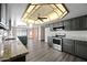 Open concept kitchen with grey cabinetry, stainless appliances, stone countertops, and an island sink at 5434 E Acoma Dr, Scottsdale, AZ 85254