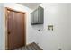 A simple laundry room featuring grey shaker cabinets and a modern door at 5434 E Acoma Dr, Scottsdale, AZ 85254
