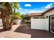 A backyard patio featuring brick pavers, privacy walls, and a lush tropical tree at 5434 E Acoma Dr, Scottsdale, AZ 85254