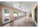Bright sunroom with wood paneling, tile floor, ceiling fans, and backyard access at 5434 E Acoma Dr, Scottsdale, AZ 85254