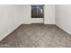 An empty bedroom featuring tile flooring, white walls, and a window providing natural light at 5654 W Villa Theresa Dr, Glendale, AZ 85308