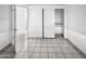 Bedroom featuring a sliding door closet, tile flooring, and white walls at 5654 W Villa Theresa Dr, Glendale, AZ 85308